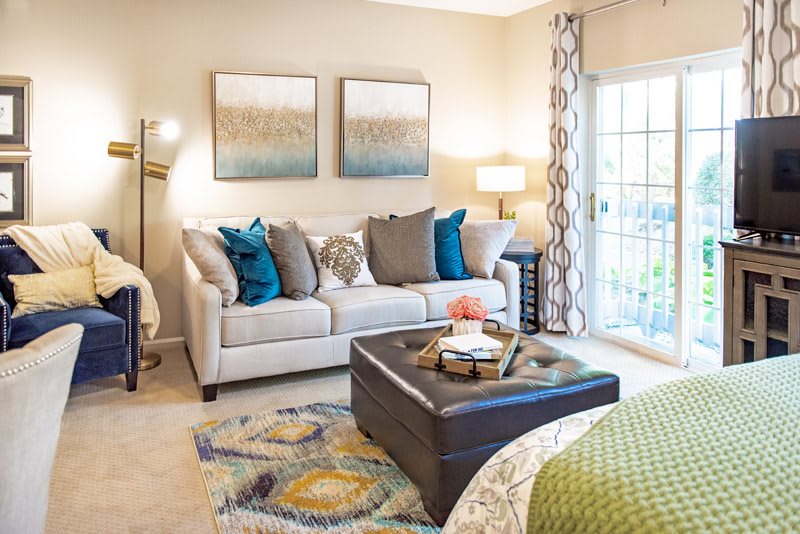 A cozy living room with a light-colored sofa, decorative cushions, and a central coffee table adorned with accessories.