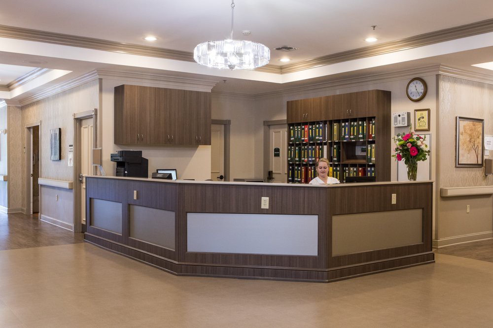 A modern reception desk in an office lobby with organized shelving and contemporary lighting.