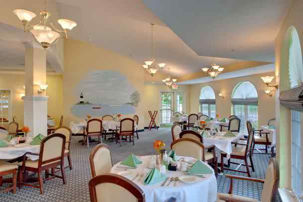 A brightly lit restaurant dining room with elegantly set tables and comfortable chairs.