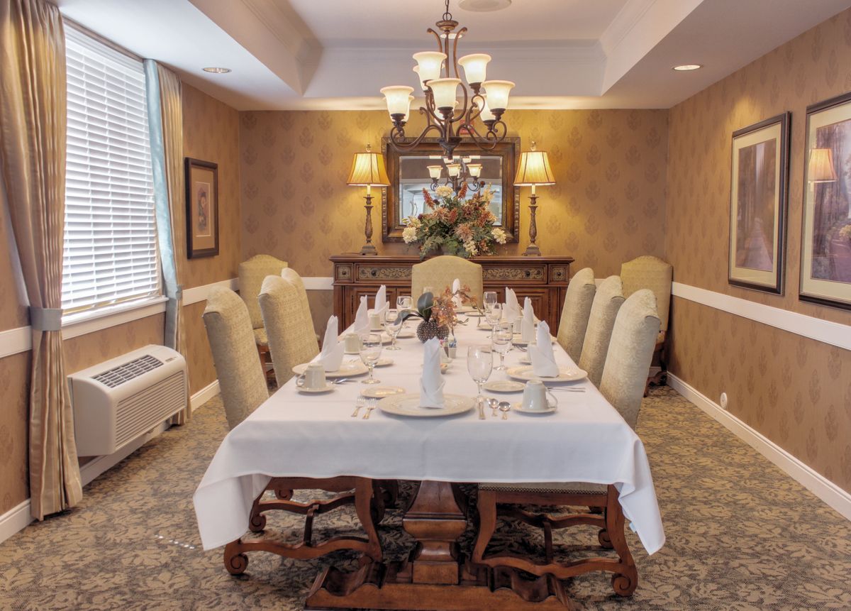 A beautifully set formal dining room with an elegant table setting and a chandelier.