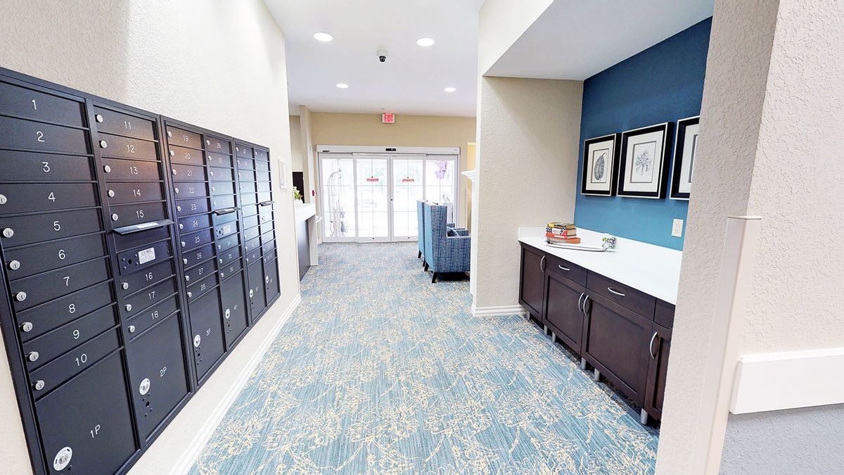 A well-lit hallway with mailboxes and modern furnishings.