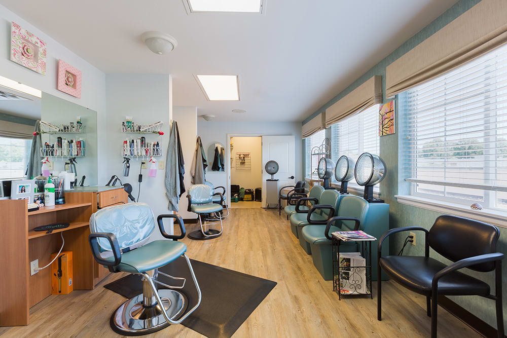 A cozy salon interior with chairs, hairdryers, and mirrors.