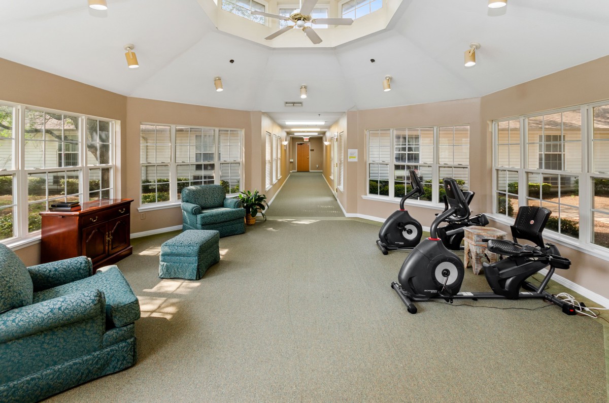 A modern indoor gym area featuring stationary bikes and comfortable seating.