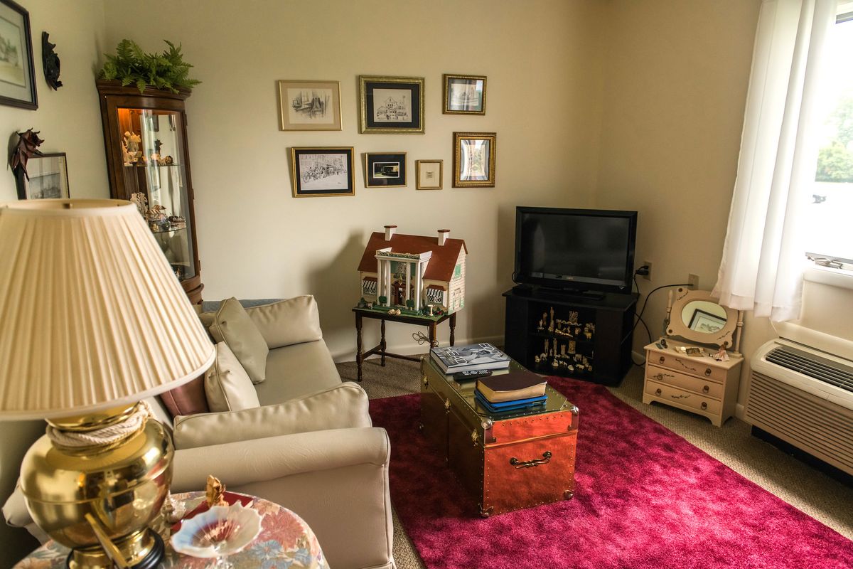 A cozy living room with a sofa, television, and decorated walls.