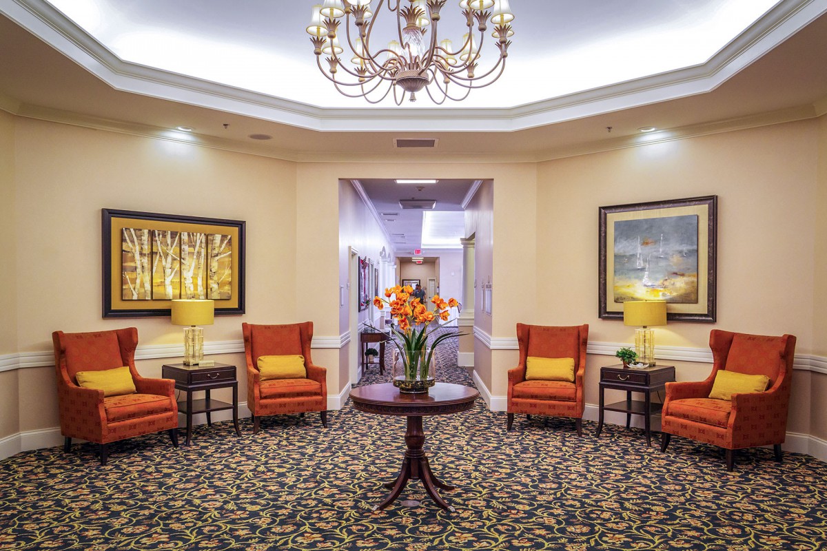 A warmly decorated lobby with comfortable seating and elegant chandelier.