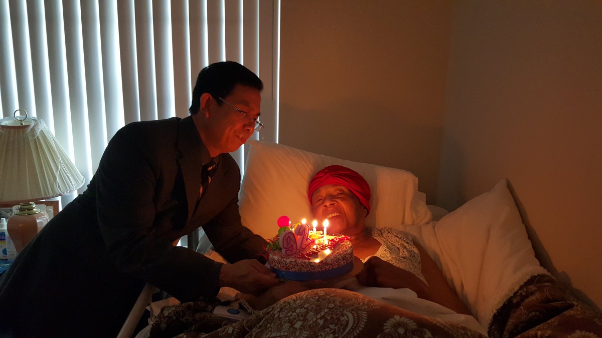 A heartfelt birthday celebration in a hospital room, with a cake and lit candles.
