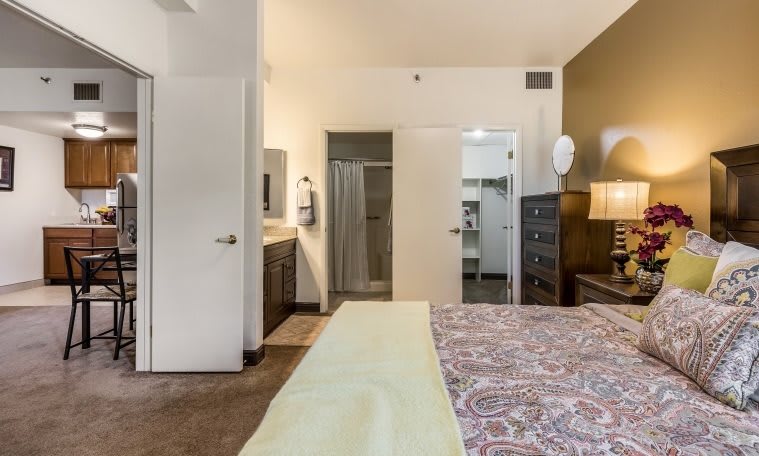 A modern hotel room with a view of the bathroom area and cozy furnishings.
