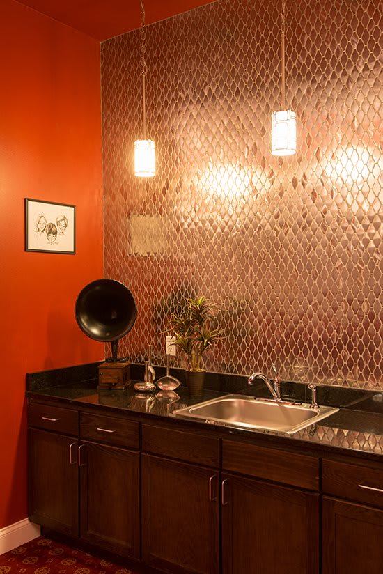 A stylish kitchen area with red walls, a vintage gramophone, and modern lighting.