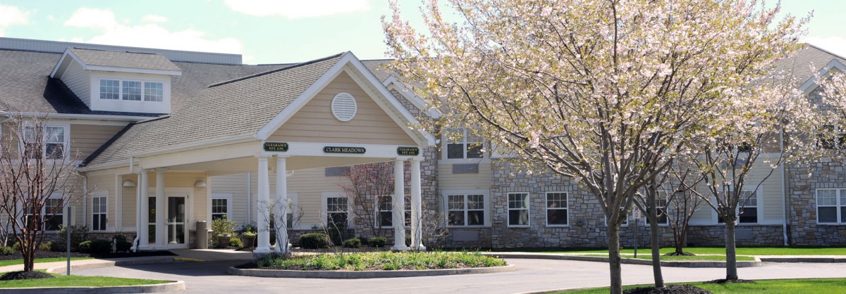 Entrance of a building surrounded by trees on a sunny day.