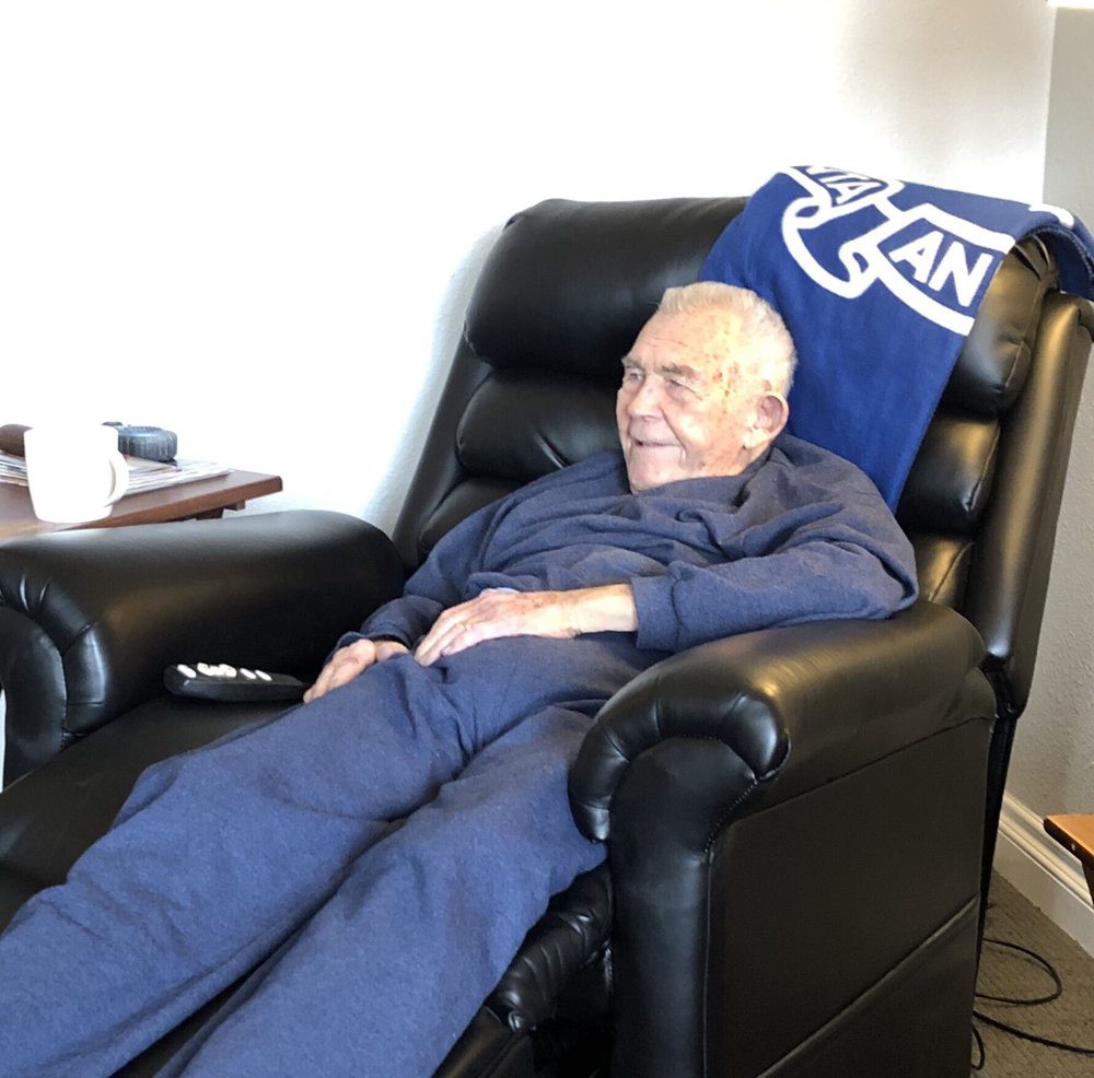 An elderly man relaxing in a recliner at home.