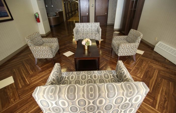 A cozy seating area in a lobby with patterned chairs and a sofa surrounding a coffee table.
