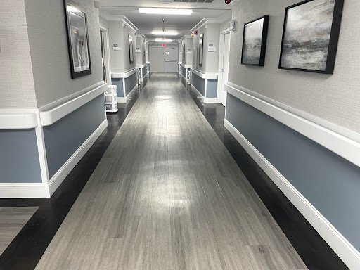A well-lit hallway featuring a modern design with framed pictures on the walls.