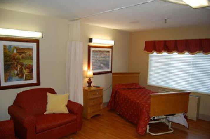 A cozy room with a bed, sofa, and warm lighting.