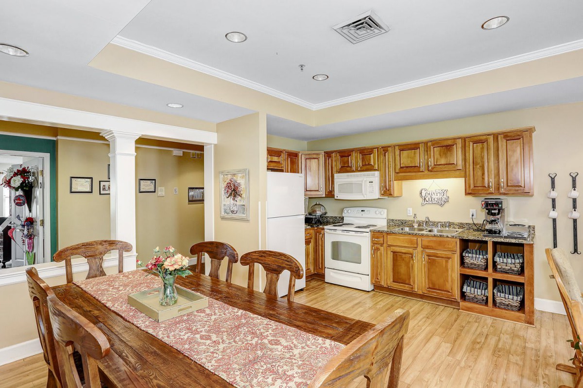 A modern kitchen and dining area featuring wooden cabinets and a table set for four.