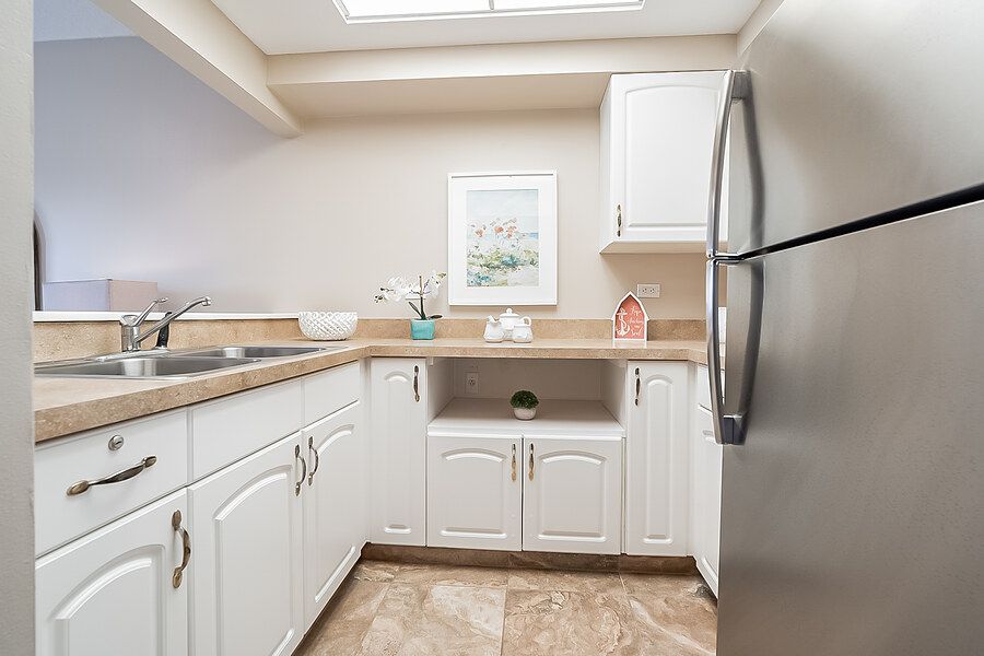 A clean and modern kitchen with white cabinets and stainless steel appliances.