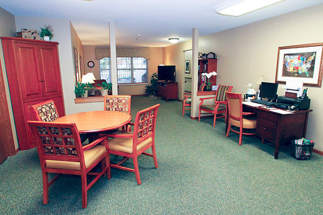 A well-furnished office space with tables, chairs, and a computer area.