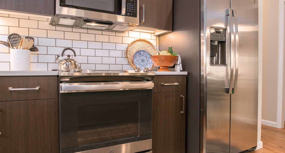 A modern kitchen with stainless steel appliances and a subway tile backsplash.