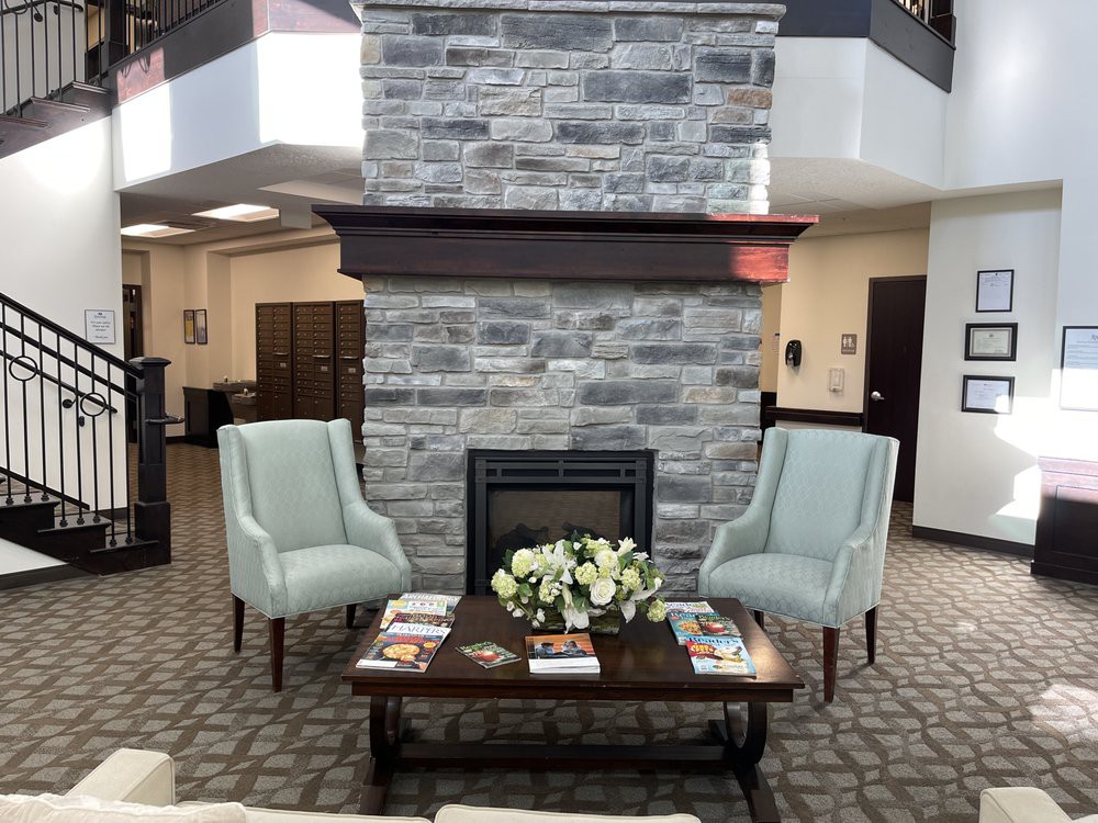 A cozy lobby seating area with a fireplace and two armchairs.