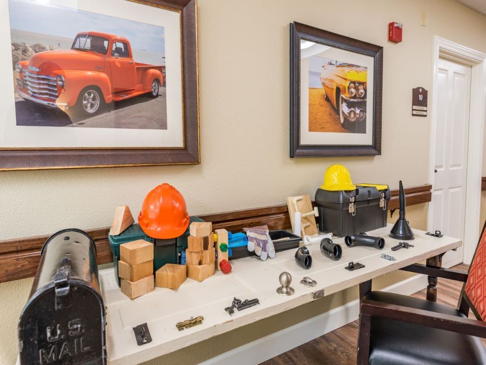 A table display featuring various tools and safety gear, including hard hats, set against a wall with framed truck photos.