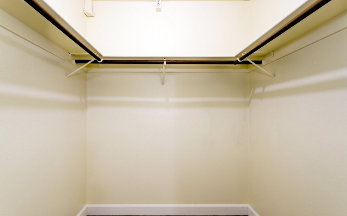 An empty closet with hanging rods in a home interior.