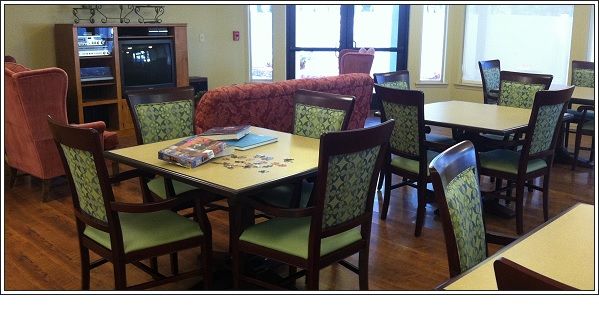 A cozy room with tables and chairs, featuring a puzzle in progress.