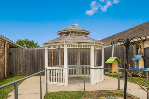 A white gazebo surrounded by lush green grass, perfect for relaxation in an outdoor space.