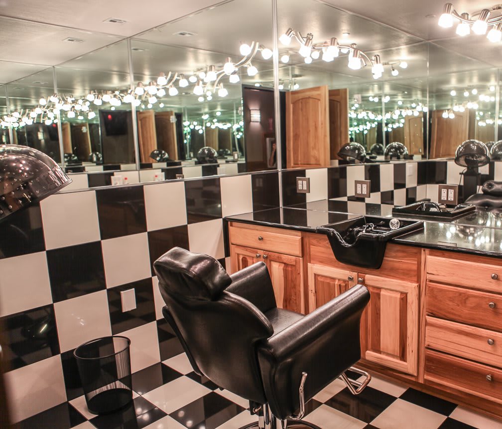 A stylish barbershop interior featuring black and white checkered tiles, mirrors, and a classic barber chair.