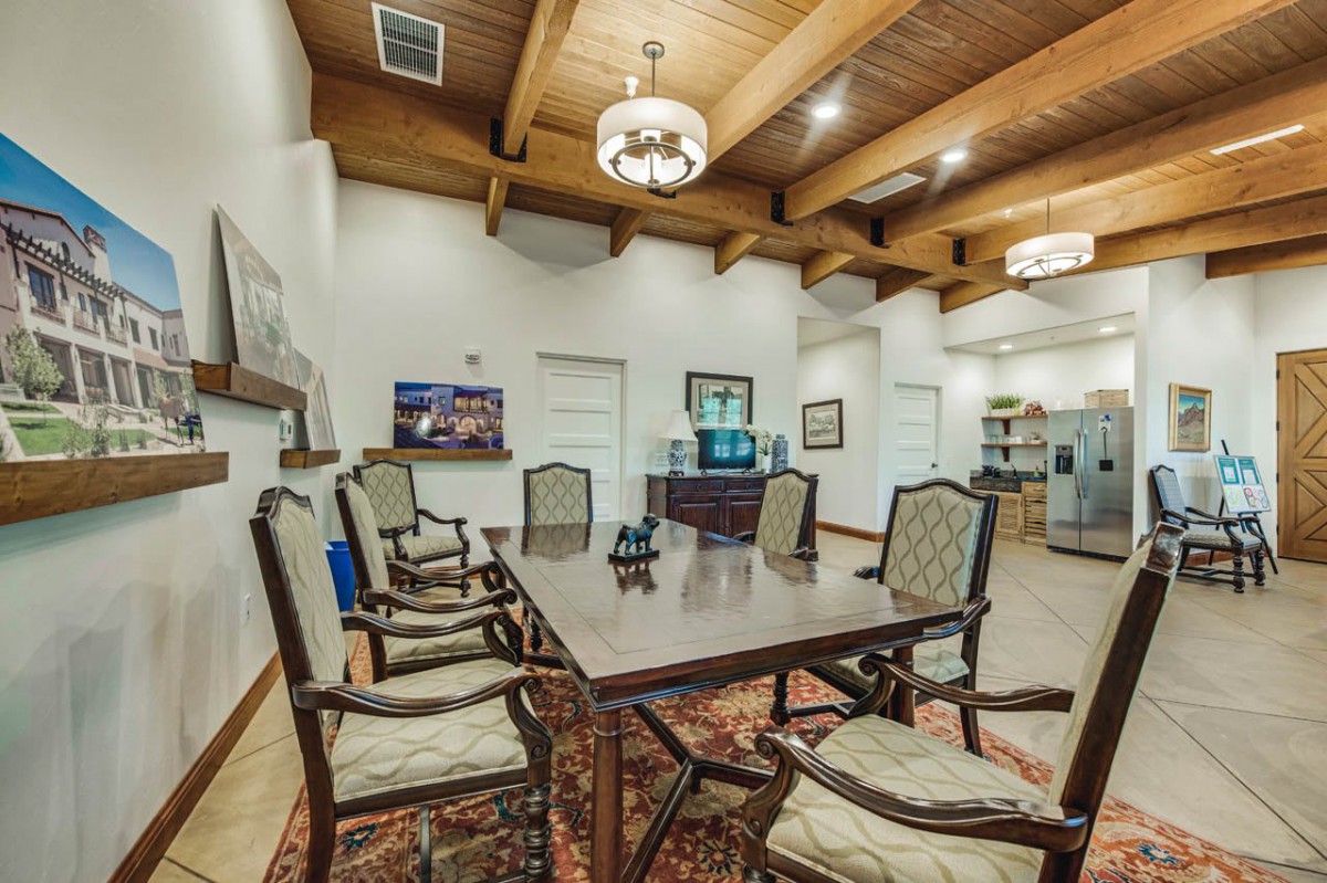 A well-appointed conference room featuring a large meeting table, elegant chairs, and decorative ceiling beams.