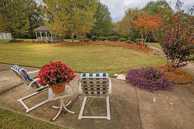 A peaceful garden view with patio furniture and lush landscaping.