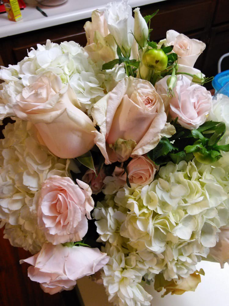 A beautifully arranged bouquet featuring pink roses and white hydrangeas.