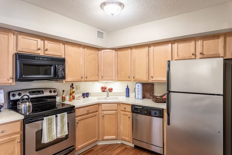 A modern kitchen with stainless steel appliances and wooden cabinets.