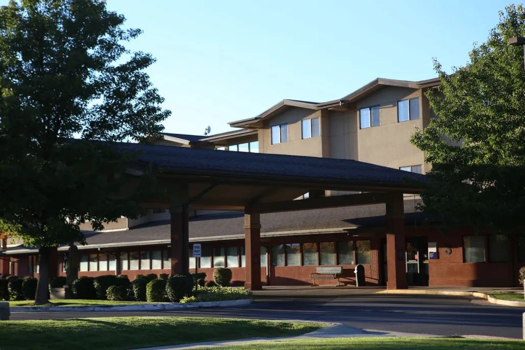A hospital building with a modern architectural design under a clear sky.
