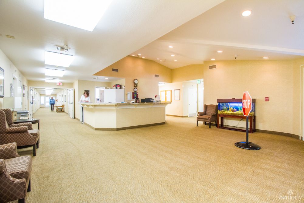 A spacious and well-lit hotel lobby with a reception desk and seating area.