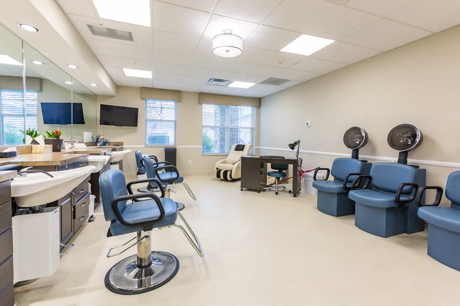 A bright and spacious hair salon with chairs, mirrors, and styling equipment.