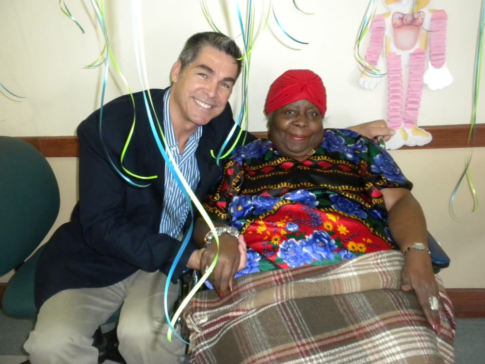 Two people sitting together, smiling and surrounded by festive decorations.