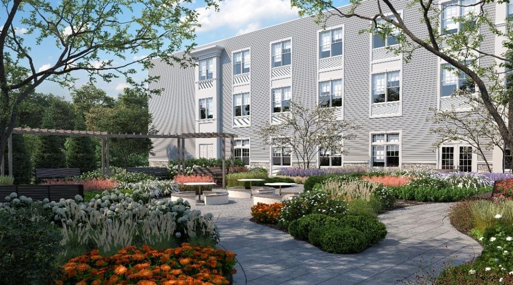 A modern building with a beautifully landscaped courtyard featuring flowers and seating areas.