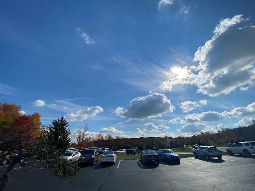 A bright autumn day with scattered clouds over a parking lot.