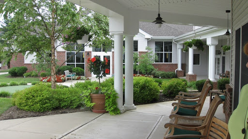 A serene view of a porch leading to a lush garden area.