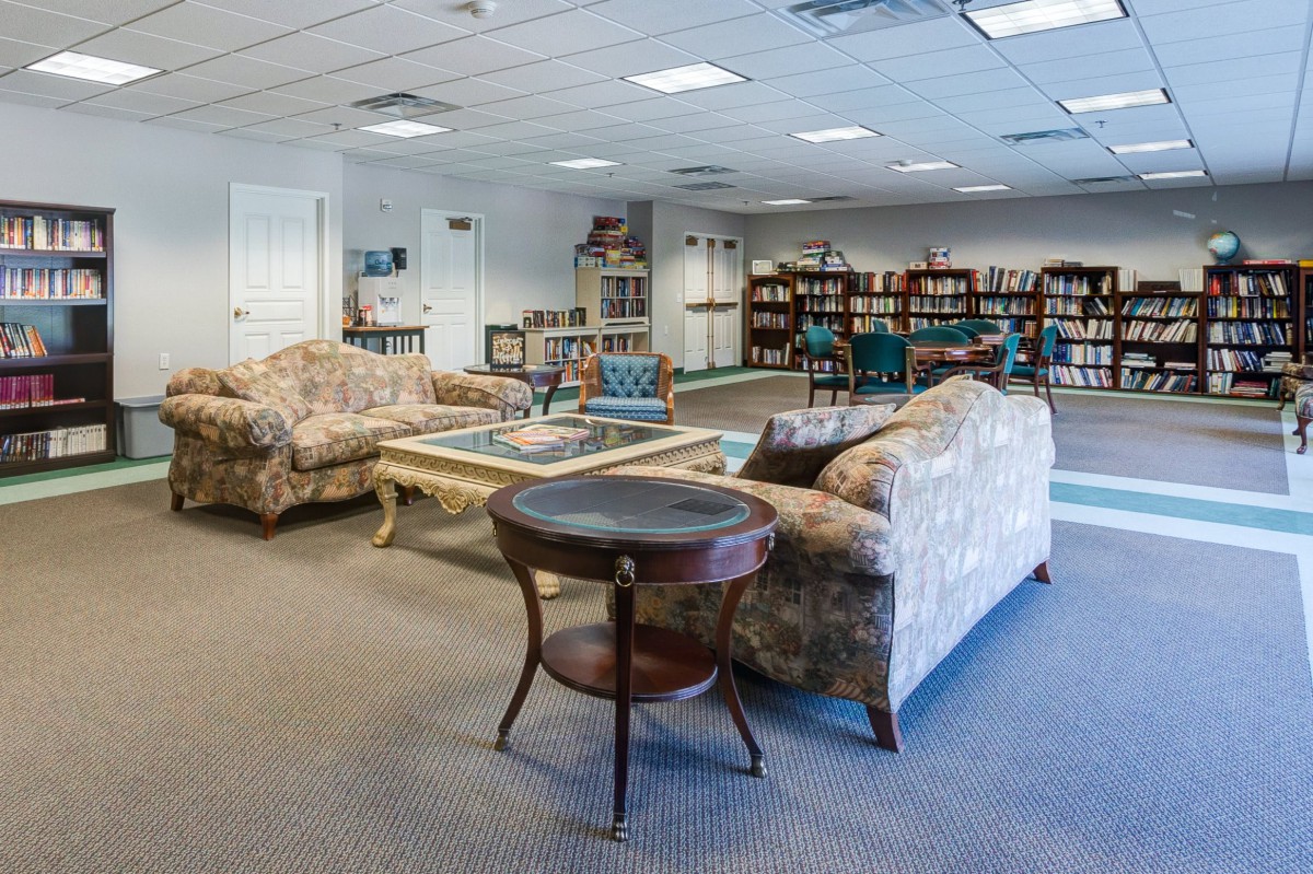 A cozy reading area within a library featuring bookshelves and comfortable seating.