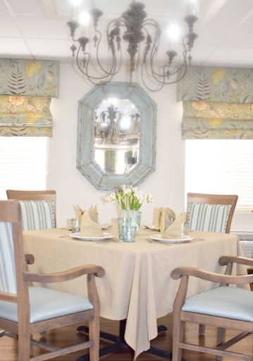 A beautifully set dining room featuring elegant decor and a charming floral centerpiece.