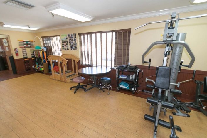 A small indoor gym featuring various exercise equipment and a play area.