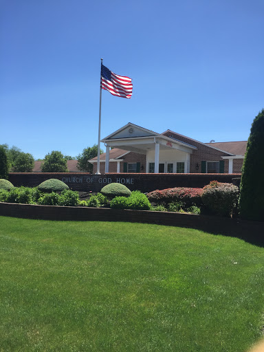 A well-maintained building with a lush green lawn and a prominent American flag waving in the breeze.