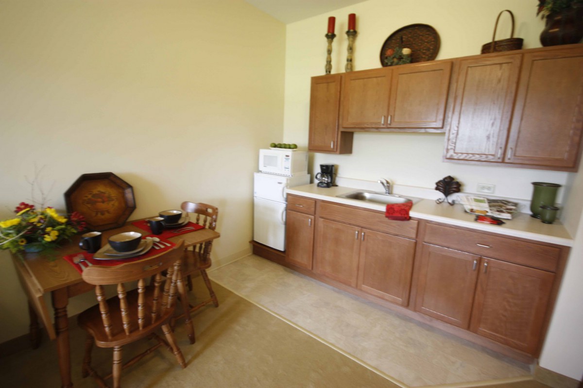 A cozy kitchen with wooden cabinets and a dining table set for breakfast.