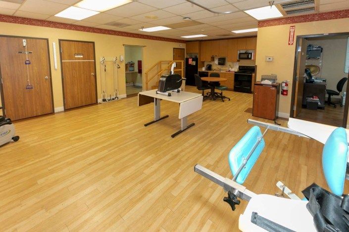 A spacious rehabilitation room equipped with exercise machines and therapy stations.