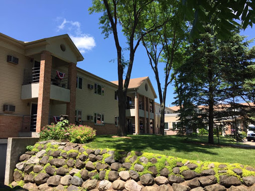 A serene residential building surrounded by trees and lush greenery.
