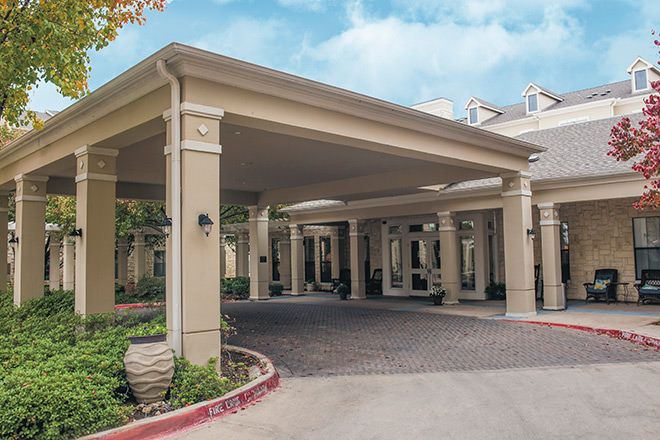 A building entrance with a covered driveway and stylish columns.