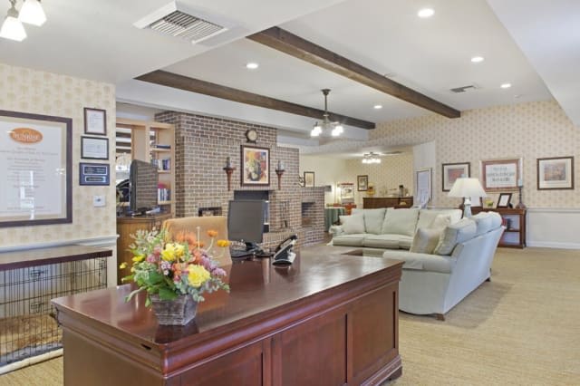 A welcoming reception area with a wooden desk, comfortable sofas, and a cozy fireplace.
