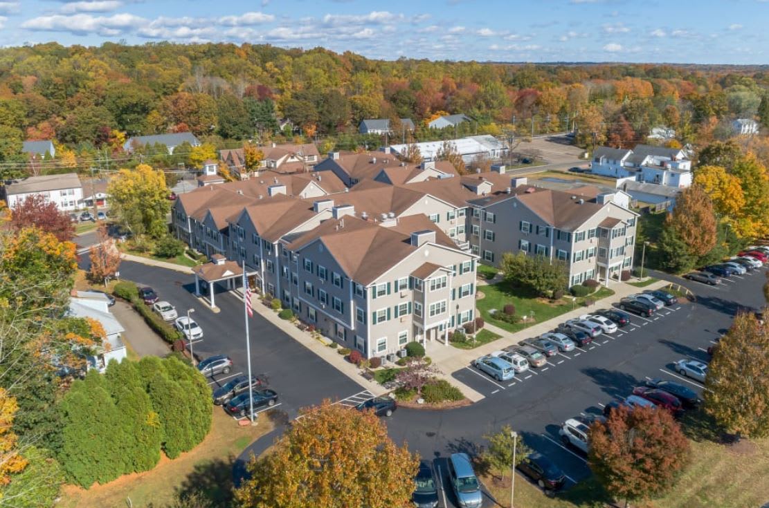 Aerial view of a residential complex surrounded by autumn foliage.