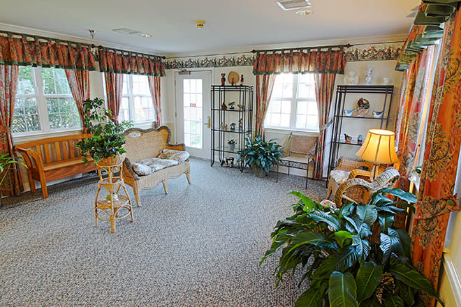 A cozy living room with elegant furniture, large windows, and decorative plants.