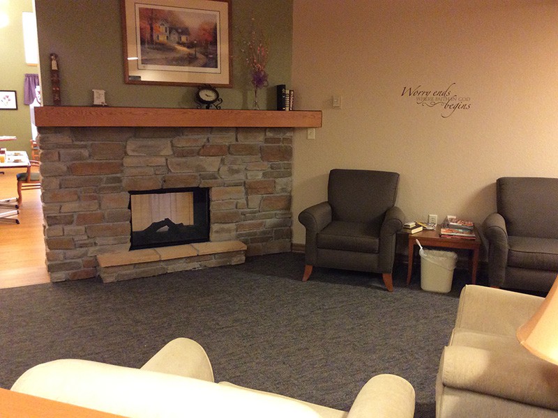 A cozy living room with a stone fireplace and comfortable armchairs.